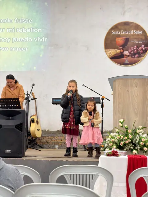 Momento de adoración durante un culto de la ADMFC